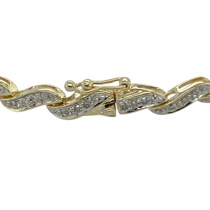 Bring elegance, sparkle, and timeless style to your collection with this pre-owned 9ct yellow gold diamond wave bracelet—a graceful design that combines fluid movement with refined brilliance.

Design: The bracelet features a flowing wave pattern adorned with sparkling diamonds, creating a continuous line of shimmer that catches the light beautifully. The delicate curvature of the links adds a touch of sophistication and modern elegance.