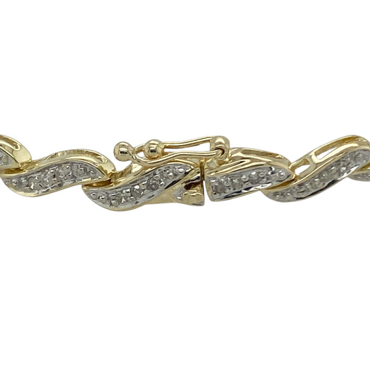 Bring elegance, sparkle, and timeless style to your collection with this pre-owned 9ct yellow gold diamond wave bracelet—a graceful design that combines fluid movement with refined brilliance.

Design: The bracelet features a flowing wave pattern adorned with sparkling diamonds, creating a continuous line of shimmer that catches the light beautifully. The delicate curvature of the links adds a touch of sophistication and modern elegance.