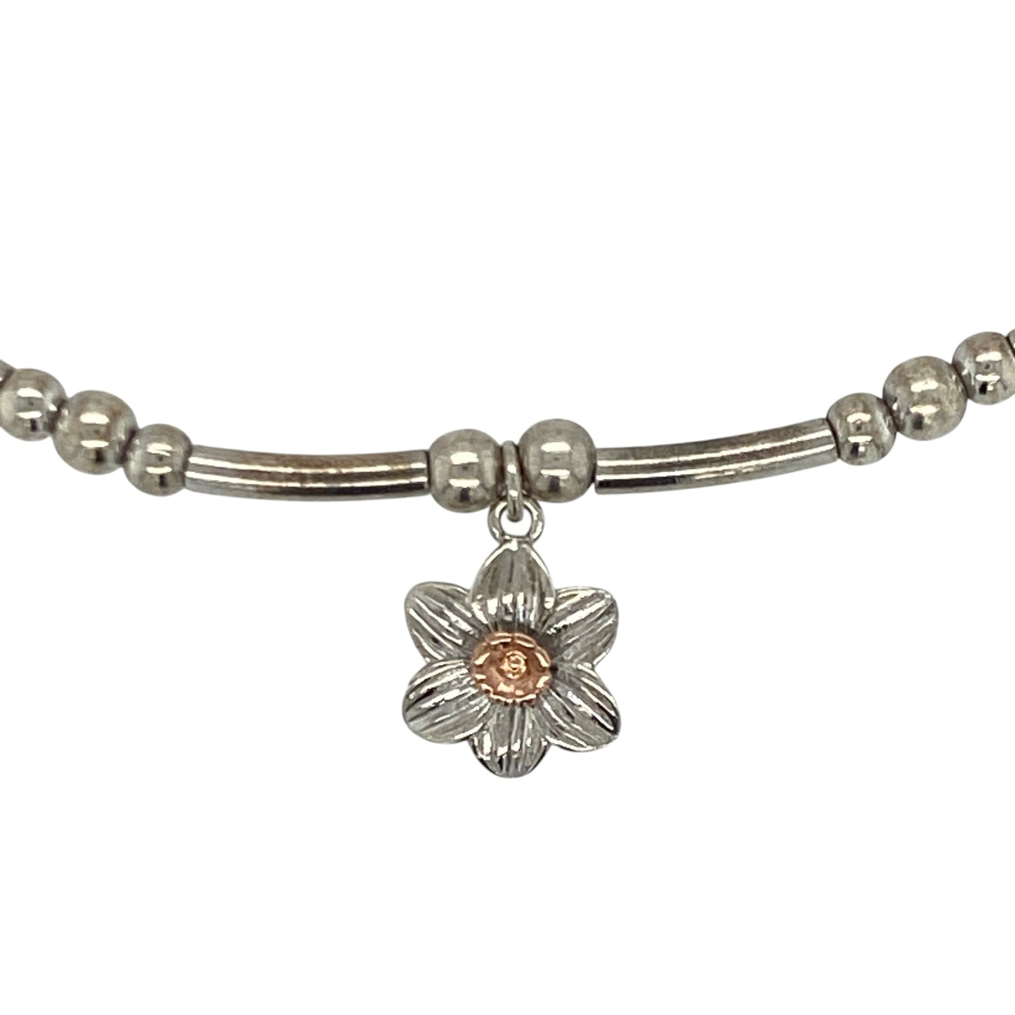 Bring symbolic charm and elegant contrast to your collection with this pre-owned Clogau daffodil stretchy affinity bracelet—an attractive piece offering Welsh heritage and refined feminine style.

Design: This bracelet features a flexible stretchy band adorned with a 9mm daffodil charm, celebrating the national flower of Wales with delicate, detailed craftsmanship.