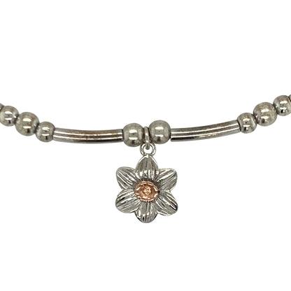 Bring symbolic charm and elegant contrast to your collection with this pre-owned Clogau daffodil stretchy affinity bracelet—an attractive piece offering Welsh heritage and refined feminine style.

Design: This bracelet features a flexible stretchy band adorned with a 9mm daffodil charm, celebrating the national flower of Wales with delicate, detailed craftsmanship.