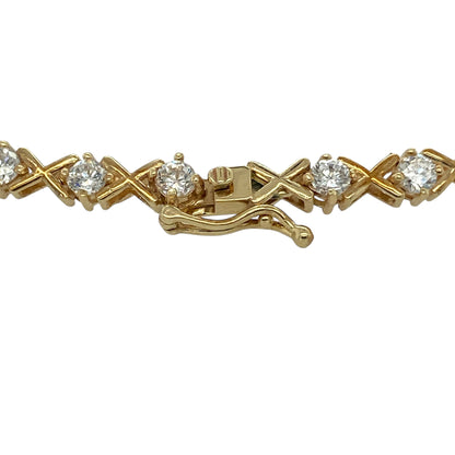 Bring sparkle, elegance, and warm golden shine to your jewellery collection with this pre-owned 9ct yellow gold and cubic zirconia 7" bracelet—an eye-catching piece that blends timeless style with radiant brilliance.

Design: This beautifully arranged bracelet features alternating 3mm cubic zirconia stones and stylish ‘X’ kiss-shaped links, creating a flowing pattern that catches the light with every movement. The combination of sparkle and polished gold offers a refined yet contemporary look.