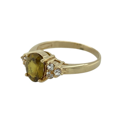 Bring vibrant colour and refined sparkle to your jewellery collection with this pre-owned 9ct yellow gold sphene and white topaz set ring, a striking piece with distinctive charm.

Design: This ring features an oval sphene at the centre, known for its lively fire and brilliance, complemented by white topaz accents that enhance its sparkle and balance the design.
