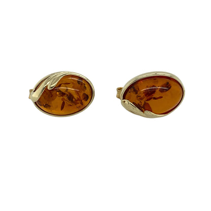 Bring warm natural tones and classic elegance to your jewellery collection with this pre-owned 9ct yellow gold amber oval stud earrings, a timeless pair with distinctive character.

Design: These stud earrings feature smooth oval amber stones, showcasing rich honeyed hues and a refined, understated silhouette.
Material: Made from 9-carat yellow gold, the warm polished finish beautifully complements the natural glow of the amber.