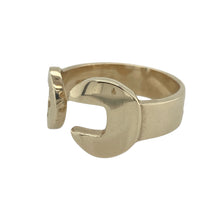 Load image into Gallery viewer, Bring bold design and industrial edge to your jewellery collection with this pre-owned 9ct yellow gold spanner style torque ring—blending statement style with mechanical-inspired charm.

Design: A spanner-shaped front measuring 12mm at its widest point wraps around in an open torque style, creating a unique and eye-catching silhouette.
Material: Made from 9-carat yellow gold, the polished finish enhances the ring’s sculptural shape and adds a sleek, modern touch.

