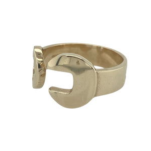 Bring bold design and industrial edge to your jewellery collection with this pre-owned 9ct yellow gold spanner style torque ring—blending statement style with mechanical-inspired charm.

Design: A spanner-shaped front measuring 12mm at its widest point wraps around in an open torque style, creating a unique and eye-catching silhouette.
Material: Made from 9-carat yellow gold, the polished finish enhances the ring’s sculptural shape and adds a sleek, modern touch.
