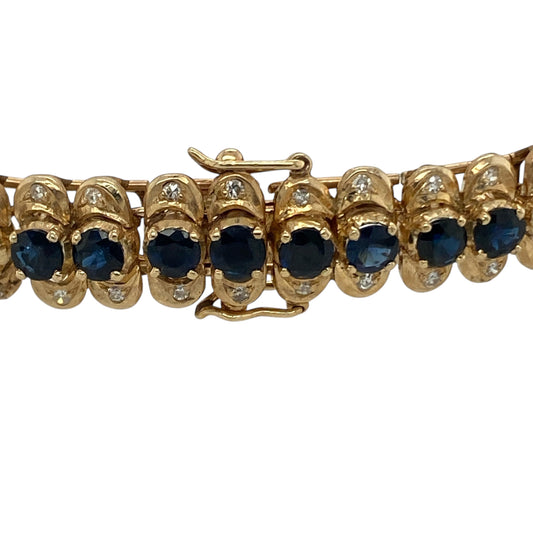 Bring vibrant colour and refined sparkle to your collection with this pre-owned 14ct yellow gold diamond and sapphire bracelet—a timeless design that combines classic gemstones with elegant craftsmanship.

Design: The bracelet features a continuous line of rich blue sapphires, each measuring approximately 3mm in diameter, with a sparkling diamond set above and below each gemstone. The alternating pattern creates a beautiful rhythm of colour and brilliance.