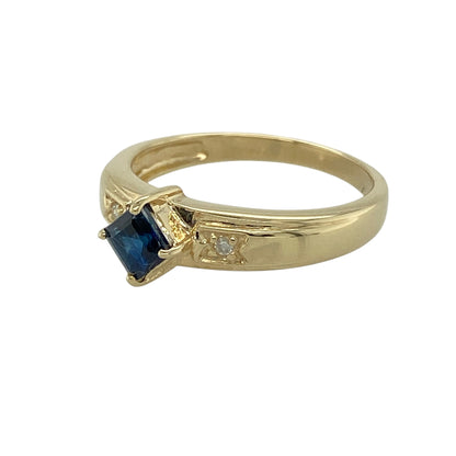 Bring deep colour and refined sparkle to your jewellery collection with this pre-owned 9ct yellow gold diamond & Tibetan kyanite set ring, a distinctive design with elegant contrast.

Design: The ring features a square Tibetan kyanite stone measuring 4mm by 4mm, displaying a rich dark blue hue that creates a striking focal point, accented with diamonds for added brilliance.