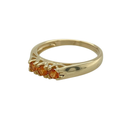 Bring warm colour and timeless symbolism to your jewellery collection with this pre-owned 9ct yellow gold orange sapphire set trilogy ring, a refined design with vibrant character.

Design: The ring features a classic trilogy arrangement of three round orange sapphire stones, each measuring approximately 3mm in diameter, creating a bright and eye-catching focal point.
Material: Made from polished 9-carat yellow gold, the warm tone beautifully enhances the rich orange hues of the sapphires.
