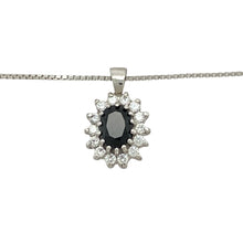 Load image into Gallery viewer, Add classic sparkle and rich colour to your jewellery collection with this pre-owned 9ct white gold sapphire and cubic zirconia cluster pendant necklace, featuring:

Design: A timeless cluster setting with a deep blue central stone surrounded by brilliant cubic zirconia, creating a radiant and refined look.
Material: 9-carat white gold, offering a cool, polished finish that enhances the brilliance of the stones.
