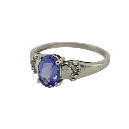 Add elegant colour and refined sparkle to your jewellery collection with this pre-owned 9ct white gold diamond and tanzanite set ring—an eye-catching piece perfect for special occasions or everyday sophistication.

Design: The ring features a beautiful oval tanzanite measuring approximately 7mm by 5mm, showcasing rich violet-blue tones and natural brilliance. Sparkling diamond accents sit either side of the centre stone, creating a balanced three-stone style look with graceful proportions.