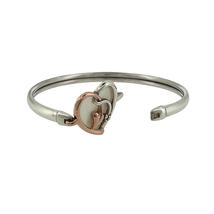 Add a meaningful and elegant piece to your jewellery collection with this pre-owned Clogau Tree of Life heart bangle, combining 925 sterling silver, 9ct rose gold and mother of pearl in a beautiful symbolic design.

Design: The bangle features a decorative heart design incorporating the iconic Tree of Life motif, creating an attractive and sentimental appearance inspired by nature.
Material: Made from 925 sterling silver with 9ct rose gold detailing, offering an elegant contrasting two-tone finish.