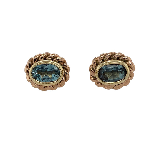 Bring elegant colour and Welsh heritage style to your jewellery collection with these pre-owned 9ct yellow and rose gold blue topaz set Clogau oval stud earrings, offering refined detail with timeless appeal—perfect for everyday wear or special occasions.

Design: The earrings feature oval blue topaz stones, each measuring approximately 7mm by 5mm, framed by a rose gold rope-style surround that adds texture and classic character.