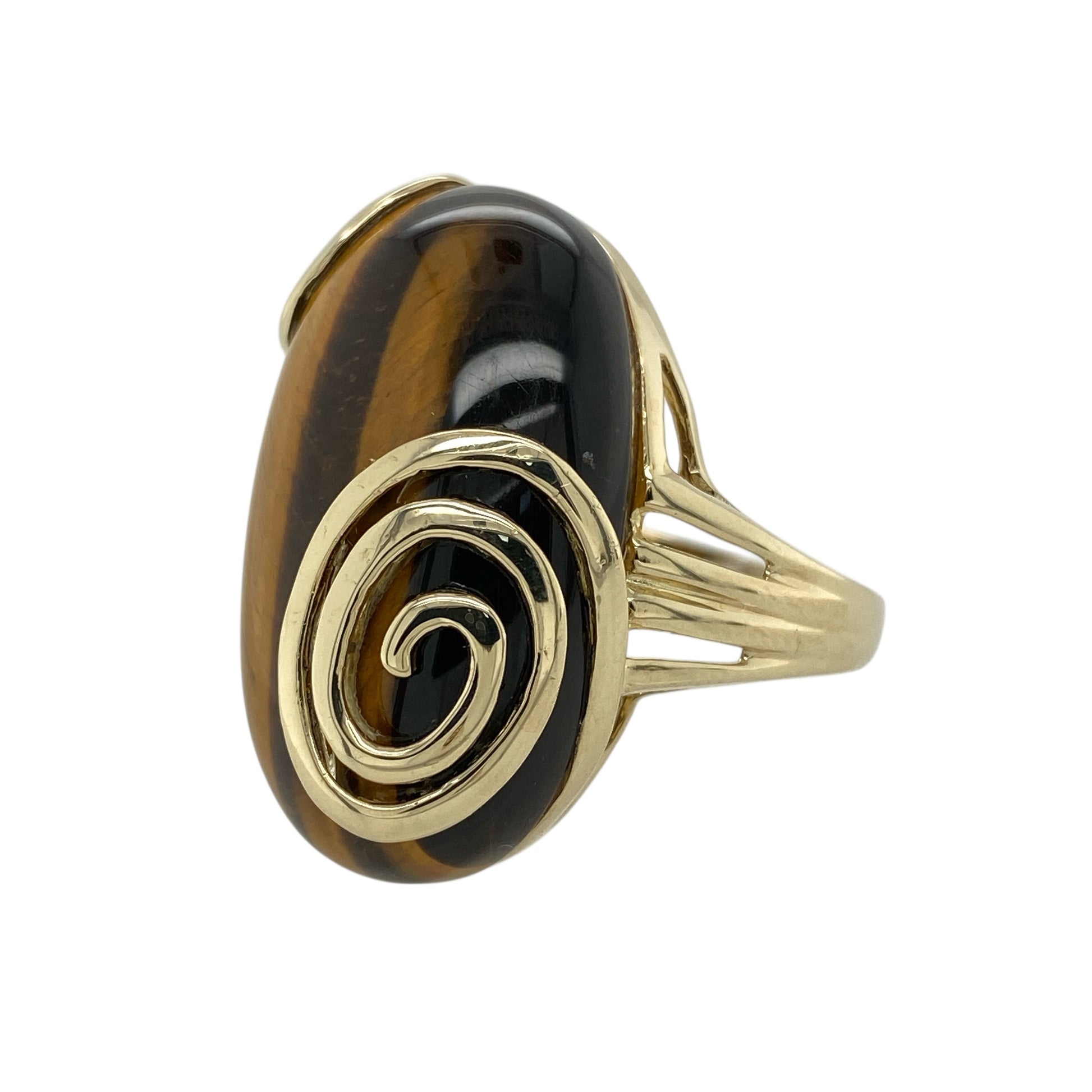 Bring bold character and natural beauty to your jewellery collection with this pre-owned 9ct yellow gold tiger’s eye set swirl edge ring, offering a striking statement design with impressive presence—perfect for those who love standout jewellery.

Design: The ring features a large oval tiger’s eye stone measuring approximately 29mm by 19mm, framed by a decorative swirl-edge setting that enhances the stone’s rich, chatoyant tones and flowing natural pattern.