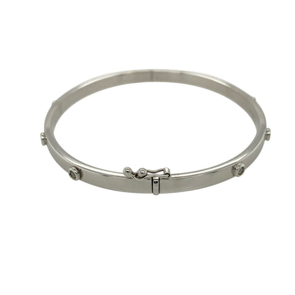 Add refined sparkle and modern elegance to your jewellery collection with this pre-owned 9ct white gold and diamond set bangle, offering a sleek design with timeless appeal—perfect for everyday wear or special occasions.

Design: The bangle features a clean, minimalist style with a width of approximately 4mm, accented by eight diamonds spaced evenly around the bangle for balanced sparkle and visual interest.