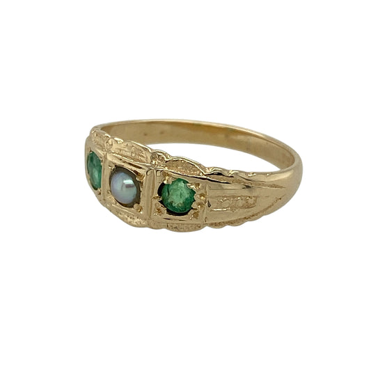 Add delicate vintage charm and refined detail to your jewellery collection with this pre-owned 9ct yellow gold emerald and seed pearl set Victorian style ring, offering timeless elegance with period-inspired design—perfect for collectors or lovers of antique styling.

Design: The ring features a patterned Victorian-style front set with a central seed pearl measuring approximately 3mm in diameter, flanked by emerald stones of similar size, creating a balanced and classic arrangement.