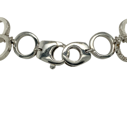 Add bold elegance and refined sparkle to your jewellery collection with this pre-owned 18ct white gold diamond circle bracelet, offering a striking design with a luxurious feel.

Design: This bracelet features circular links accented with diamonds, creating a continuous pattern of brilliance and a sophisticated, eye-catching look. The links measure approximately 12mm in width, giving the bracelet a bold and confident presence on the wrist.