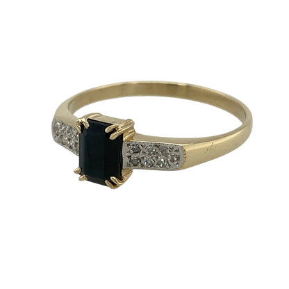 Add bold colour and classic elegance to your jewellery collection with this pre-owned 9ct yellow gold diamond and sapphire ring, offering a striking design with timeless appeal.

Design: This ring features a rectangular sapphire measuring approximately 7mm by 5mm, creating a strong and eye-catching centrepiece. Diamond accents along the shoulders add refined sparkle and beautifully frame the sapphire.