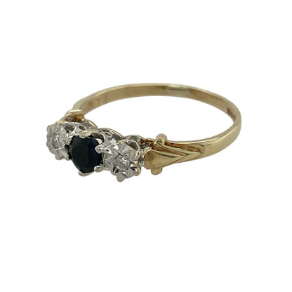 Add classic colour and meaningful sparkle to your jewellery collection with this pre-owned 9ct yellow gold diamond and sapphire trilogy ring, offering timeless design in a delicate form.

Design: This ring features a trilogy arrangement with a round sapphire at the centre measuring approximately 4mm in diameter, flanked by an illusion-style diamond on either side to enhance sparkle and visual balance.