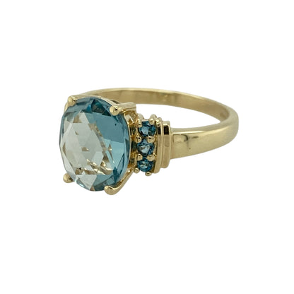 Add vibrant colour and elegant sparkle to your jewellery collection with this pre-owned 9ct yellow gold blue topaz ring, offering a bold centrepiece with refined detail.

Design: This ring features a striking oval blue topaz measuring approximately 10mm by 8mm at the centre, creating a bright and eye-catching focal point. Three smaller topaz stones are arranged on each side, adding balance and additional shimmer to the design.