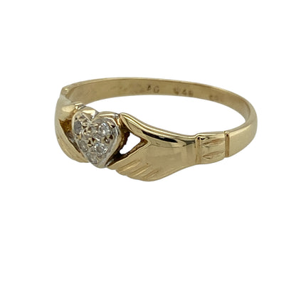 Add symbolic charm and two-tone elegance to your jewellery collection with this pre-owned 9ct yellow and white gold cubic zirconia Claddagh ring, offering meaningful design with refined sparkle.

Design: This Claddagh-style ring features the traditional hands and heart motif, symbolising love and friendship. This version does not include the crown, giving the design a simplified and distinctive look. Cubic zirconia accents add subtle brilliance to the heart detail.