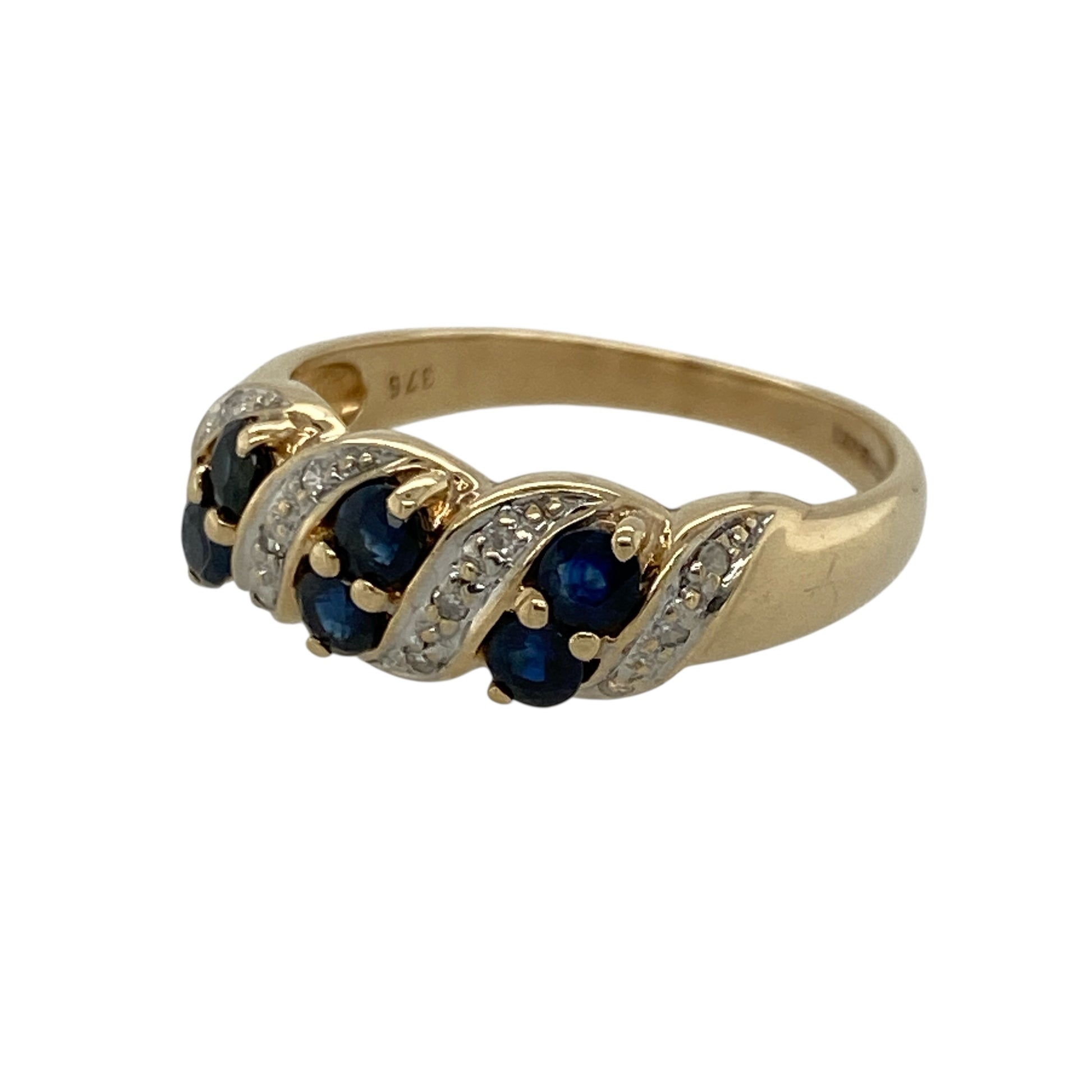 Add timeless elegance to your collection with this pre-owned 9ct yellow gold diamond and sapphire twist band ring, combining rich blue tones with classic sparkle in a beautifully flowing design. Ideal for everyday wear or as a meaningful gift.

Design: The front of the band measures approximately 7mm wide, featuring a graceful twist design set with round sapphires measuring approximately 2mm in diameter, accented by sparkling diamonds.