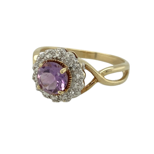 Add rich colour and refined sparkle to your jewellery collection with this pre-owned 9ct yellow gold diamond and amethyst cluster ring, featuring a striking centre stone enhanced by delicate diamond detailing. Perfect for both everyday wear and special occasions.

Design: The ring showcases a 6mm round amethyst at the centre, framed by four small diamonds arranged around it in a white gold style illusion halo setting.