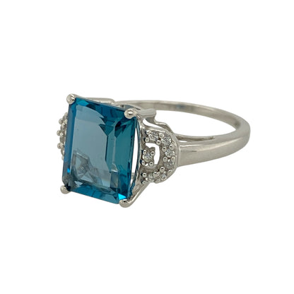 Make a statement with this pre-owned 9ct white gold diamond and blue topaz set ring, showcasing striking colour and elegant sparkle in a sophisticated design. Perfect for special occasions or adding a refined touch to everyday wear.

Design: The ring features an impressive 10mm by 8mm rectangular blue topaz as its centrepiece, offering vibrant sky-blue tones and excellent clarity.