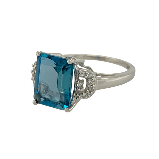 Make a statement with this pre-owned 9ct white gold diamond and blue topaz set ring, showcasing striking colour and elegant sparkle in a sophisticated design. Perfect for special occasions or adding a refined touch to everyday wear.

Design: The ring features an impressive 10mm by 8mm rectangular blue topaz as its centrepiece, offering vibrant sky-blue tones and excellent clarity.
