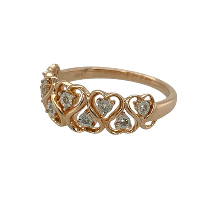 Celebrate love and delicate sparkle with this pre-owned 9ct rose gold diamond set heart band ring, featuring a romantic openwork design with refined detailing. A beautiful piece perfect for everyday wear or as a meaningful gift.

Design: The front of the band measures approximately 7mm wide and is formed from multiple open heart shapes set side by side. Each heart is accented with a small diamond at its centre, creating a continuous pattern of sparkle and sentiment across the finger.
