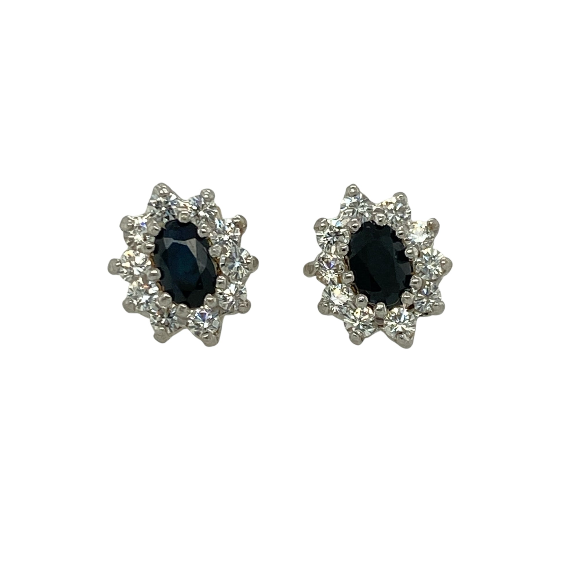 Add vibrant colour and delicate sparkle to your jewellery collection with these pre-owned 9ct yellow gold sapphire and cubic zirconia set cluster stud earrings. A timeless pair perfect for everyday elegance or special occasions.

Design: Each earring features an oval-cut sapphire measuring approximately 5mm by 3mm, forming the centre of a classic cluster design. Surrounding cubic zirconia stones enhance the overall brilliance, creating a beautifully balanced and eye-catching finish.
