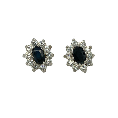 Add vibrant colour and delicate sparkle to your jewellery collection with these pre-owned 9ct yellow gold sapphire and cubic zirconia set cluster stud earrings. A timeless pair perfect for everyday elegance or special occasions.

Design: Each earring features an oval-cut sapphire measuring approximately 5mm by 3mm, forming the centre of a classic cluster design. Surrounding cubic zirconia stones enhance the overall brilliance, creating a beautifully balanced and eye-catching finish.