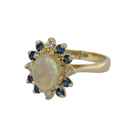 Add soft iridescence and vibrant colour to your jewellery collection with this pre-owned 9ct yellow gold diamond, Opalique and sapphire set cluster ring, offering a beautiful blend of shimmer and classic styling. A striking piece perfect for special occasions or elegant everyday wear.

Design: The ring features an oval Opalique centre stone measuring approximately 8mm by 6mm, creating a luminous focal point with a subtle play of colour.