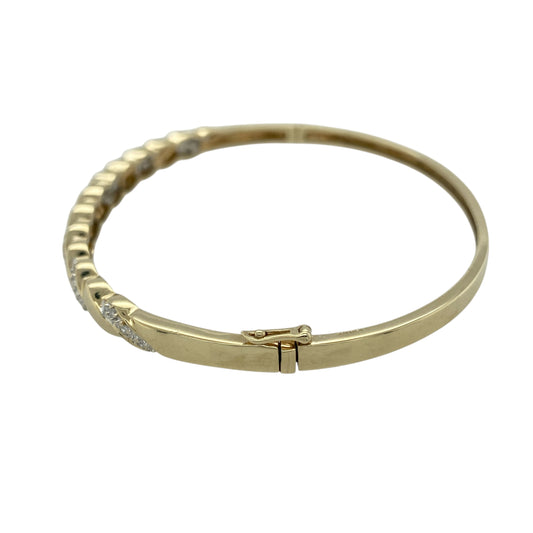 Add elegant contrast and sparkle to your jewellery collection with this pre-owned 9ct yellow and white gold diamond set twisted hinged bangle, a timeless statement piece perfect for special occasions or refined everyday wear.

Design: This bangle features a graceful twisted design across the front, measuring approximately 6mm in width. The flowing crossover style combines yellow and white gold, with diamond accents adding subtle brilliance and enhancing the movement of the twist pattern.