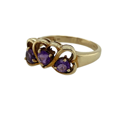 Add romantic colour to your jewellery collection with this pre-owned 9ct yellow gold amethyst set three heart ring, a meaningful and eye-catching piece perfect for everyday wear or gifting.

Design: The ring features three heart-shaped settings across the front, measuring approximately 9mm high. Each heart is set with a round amethyst measuring around 4mm in diameter, creating a beautiful trio of rich purple tones with balanced sparkle and symmetry.