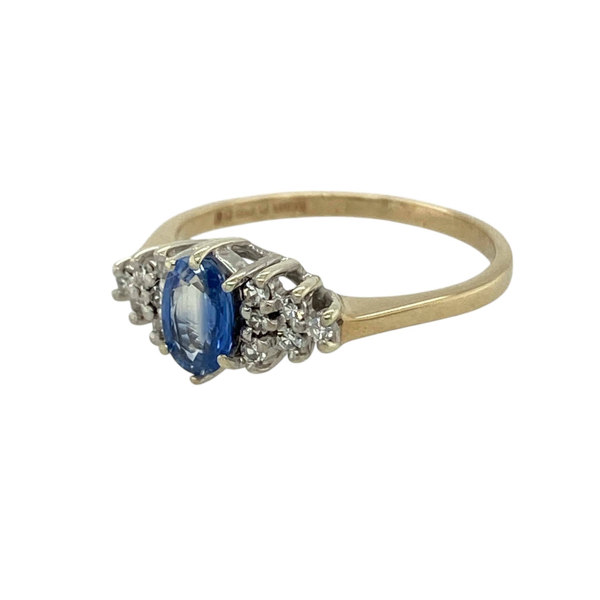 Add timeless elegance and rich colour to your jewellery collection with this pre-owned 9ct yellow gold diamond and sapphire set ring—an eye-catching design perfect for special occasions or refined everyday wear.

Design: The ring features a 6mm by 4mm oval-cut sapphire at the centre, showcasing deep blue tones and classic appeal. A cluster of sparkling diamonds sits on either side of the sapphire, enhancing its colour and creating a beautifully balanced, three-stone style look.