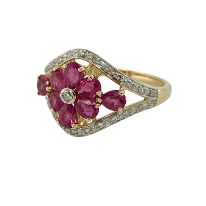 Add vibrant colour and timeless sparkle to your jewellery collection with this pre-owned 9ct yellow gold diamond and ruby set flower ring—an eye-catching statement piece perfect for special occasions or elegant everyday wear.

Design: The front of the ring measures approximately 14mm high and features a beautiful flower motif set with rich red rubies and sparkling diamonds. The floral arrangement creates a bold yet feminine silhouette, offering impressive presence on the finger.