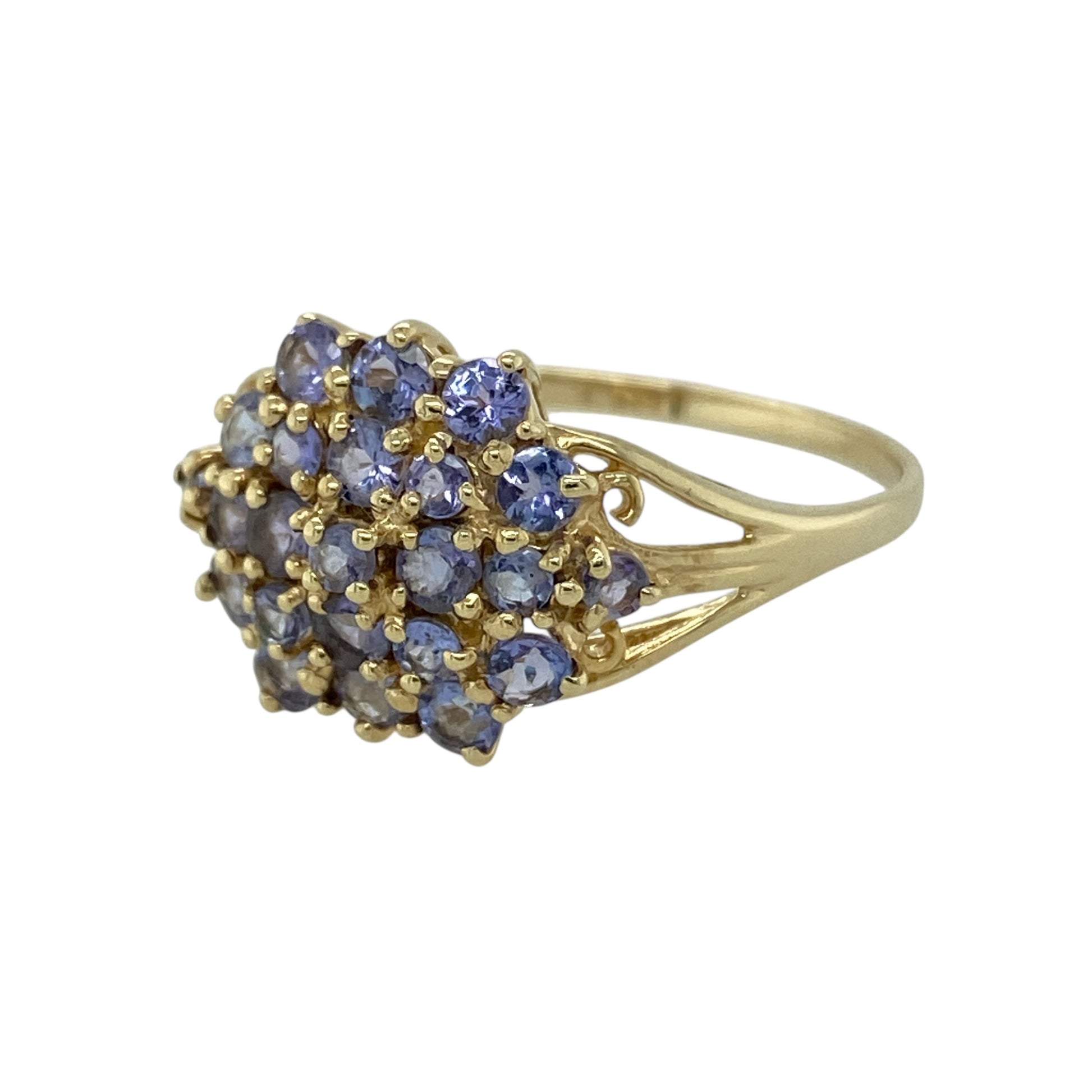 Add vibrant colour and elegant sparkle to your jewellery collection with this pre-owned 9ct yellow gold tanzanite cluster ring, featuring a bold and eye-catching design—perfect as a statement dress ring or special occasion piece.

Design: The ring showcases a beautiful cluster of tanzanite stones arranged across the front, creating a striking display of violet-blue colour. The cluster design measures approximately 14mm high, giving the ring a noticeable and elegant presence on the finger.