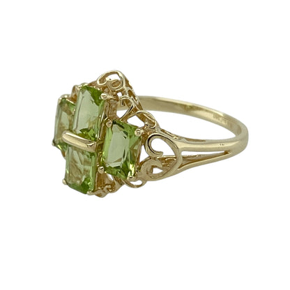 Add vibrant colour and elegant sparkle to your jewellery collection with this pre-owned 9ct yellow gold peridot cluster dress ring, featuring bright gemstones and a bold design—perfect as a statement piece or August birthstone ring.

Design: The ring showcases a cluster of rectangular peridot stones, each measuring approximately 6mm by 4mm, arranged to create a striking and eye-catching display. The vivid green tones of the peridot give the ring a fresh and lively appearance.