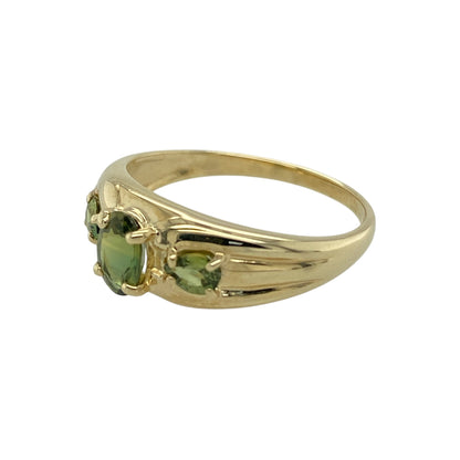 Add vibrant colour and timeless elegance to your jewellery collection with this pre-owned 9ct yellow gold peridot coloured trilogy ring, featuring a classic three stone design—perfect for everyday wear or a meaningful gift.

Design: The ring showcases a trilogy arrangement of green peridot coloured stones, with an oval centre stone measuring approximately 6mm by 4mm. The three stone layout creates a balanced and eye-catching display of colour.
