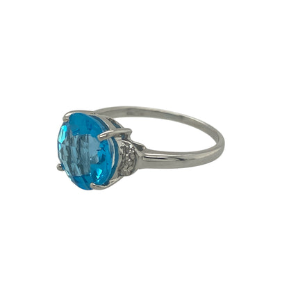 Add vibrant colour and elegant sparkle to your jewellery collection with this pre-owned 9ct yellow gold diamond and blue stone ring, featuring a bold gemstone and classic design—perfect as a statement dress ring or eye-catching everyday piece.

Design: The ring showcases a round blue centre stone measuring approximately 9mm, creating a striking focal point. Sparkling diamond accents complement the centre stone, enhancing its colour and adding refined brilliance.
