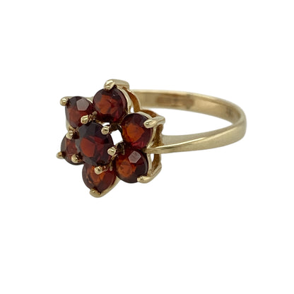 Add a touch of rich colour and vintage-inspired charm to your jewellery collection with this pre-owned 9ct yellow gold garnet set flower cluster ring, combining classic design with eye-catching detail—perfect for everyday wear or special occasions.

Design: The ring features a striking flower cluster design, with garnet stones arranged to create a bold and feminine floral shape.