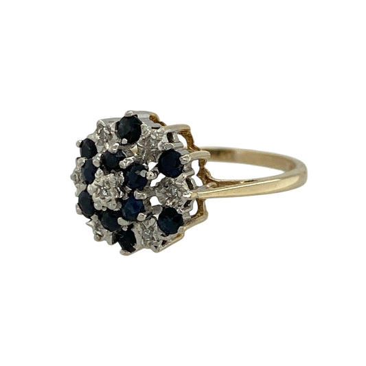 Add a bold and elegant piece to your jewellery collection with this pre-owned 9ct yellow gold diamond and sapphire set cluster ring, combining rich colour with classic sparkle—perfect for everyday wear or special occasions.

Design: The ring features a striking cluster design, showcasing multiple sapphires arranged with diamond accents to create a full and eye-catching look.