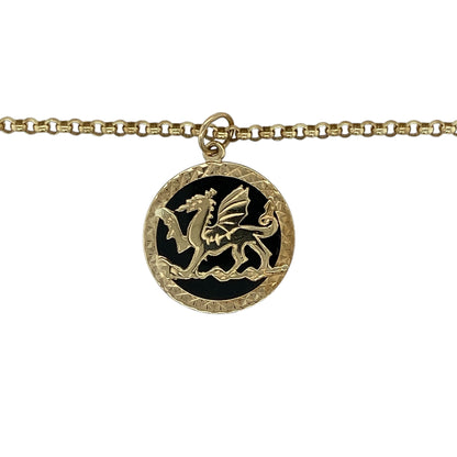 Add a bold and meaningful piece to your jewellery collection with this pre-owned 9ct yellow gold onyx backed Welsh dragon round pendant on a 21" belcher chain necklace, combining heritage symbolism with striking design—perfect for everyday wear or statement styling.

Design: The necklace features a round pendant showcasing the iconic Welsh dragon motif set against an onyx backing, creating a strong and eye-catching contrast, suspended from a classic belcher chain.