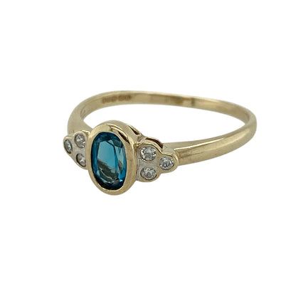 Add a refreshing touch of colour and sparkle to your jewellery collection with this pre-owned 9ct yellow gold blue topaz and cubic zirconia set ring—an elegant and versatile piece perfect for everyday wear or special occasions.

Design: This ring features a central oval blue topaz measuring approximately 6mm by 4mm, creating a bright and eye-catching focal point, complemented by sparkling cubic zirconia for added brilliance.