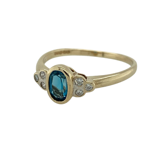 Add a refreshing touch of colour and sparkle to your jewellery collection with this pre-owned 9ct yellow gold blue topaz and cubic zirconia set ring—an elegant and versatile piece perfect for everyday wear or special occasions.

Design: This ring features a central oval blue topaz measuring approximately 6mm by 4mm, creating a bright and eye-catching focal point, complemented by sparkling cubic zirconia for added brilliance.