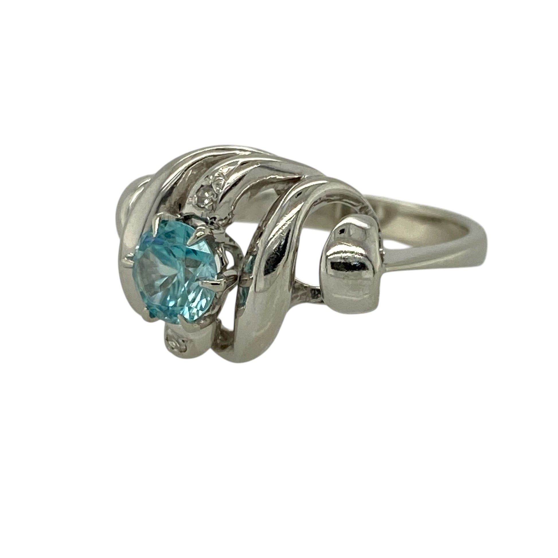 Add flowing elegance and vibrant colour to your jewellery collection with this pre-owned 18ct white gold diamond and blue topaz set wave style ring—an eye-catching piece perfect for special occasions or everyday wear.

Design: This ring features a graceful wave-style design, centred with a round blue topaz measuring approximately 6mm in diameter, complemented by sparkling diamonds that enhance the fluid and contemporary look.