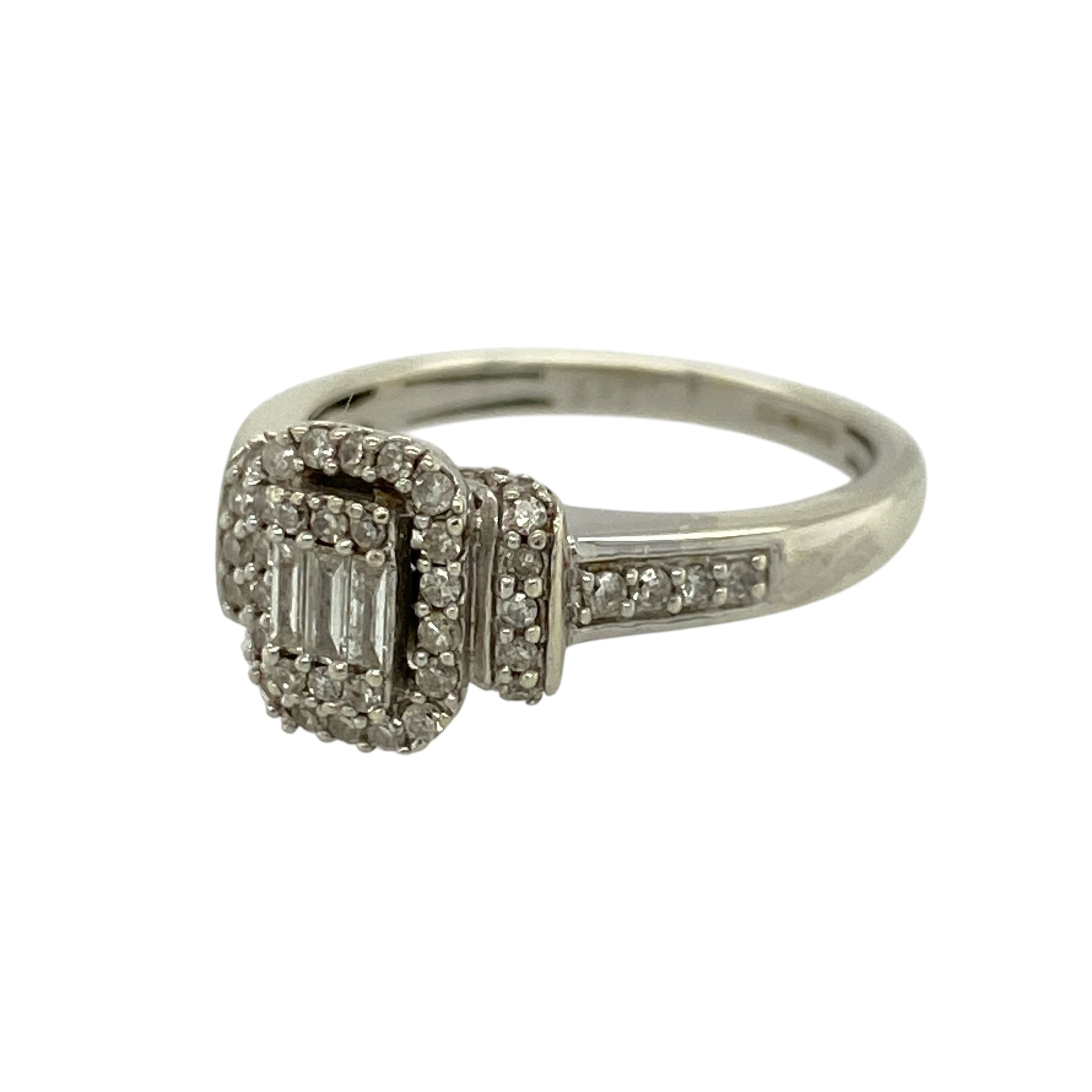 Add elegant sparkle and modern design to your jewellery collection with this pre-owned 9ct white gold diamond set rectangle halo ring—an eye-catching piece perfect for special occasions or everyday wear.

Design: This ring features a striking rectangular halo front measuring approximately 9mm high, set with three baguette-cut diamonds at the centre, surrounded and complemented by multiple brilliant-cut diamonds extending onto the shoulders for added brilliance.