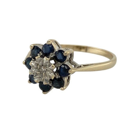 Add a touch of floral elegance and vibrant sparkle to your jewellery collection with this pre-owned 9ct yellow gold diamond and sapphire set flower cluster ring—an eye-catching piece perfect for everyday wear or special occasions.

Design: This ring features a beautiful flower cluster design with a 12mm high front, combining rich blue sapphires and sparkling diamonds to create a bold and decorative focal point.