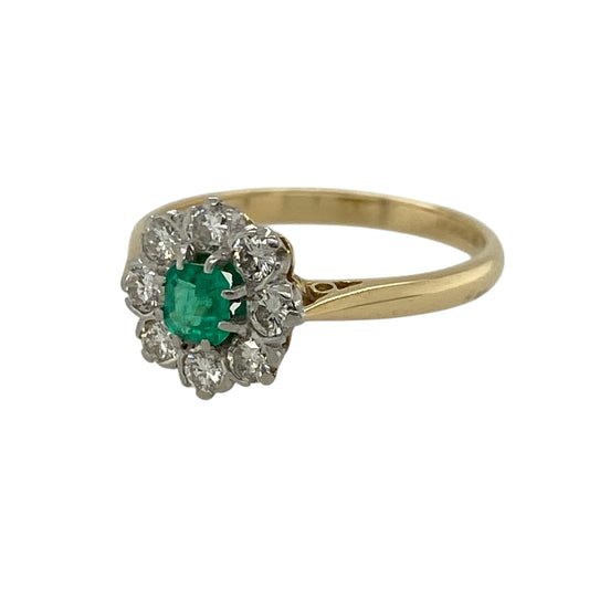Add a touch of classic elegance and rich colour to your jewellery collection with this pre-owned 18ct yellow gold diamond and emerald set cluster ring—an eye-catching piece perfect for everyday wear or special occasions.

Design: This ring features a central emerald measuring approximately 3mm in diameter, surrounded by sparkling diamonds that create a delicate and radiant cluster design.