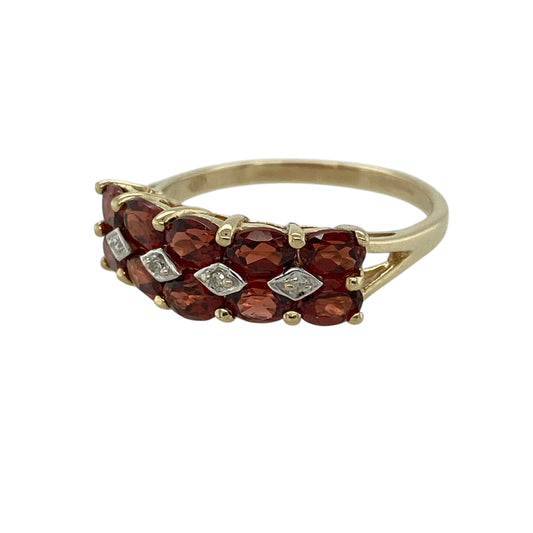 Add rich colour and elegant sparkle to your jewellery collection with this pre-owned 9ct yellow gold diamond and garnet set cluster band ring—an eye-catching piece perfect for everyday wear or special occasions.

Design: This band ring features a 6mm wide front, set with ten oval garnet gemstones, each measuring approximately 4mm by 3mm, creating a bold and vibrant cluster design across the finger.